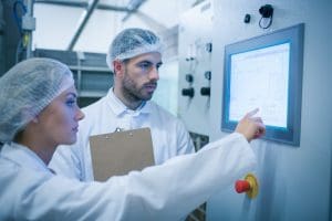 Production supervisors reviewing data and managing her co-worker