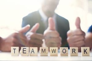“Teamwork” word on business working table. Wooden cross word alphabet “Teamwork”. Business teamwork concept.