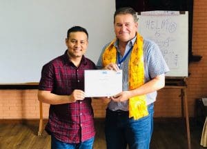 A photo of Nirpa Dhami with his certificate with Haydn Sandvig.